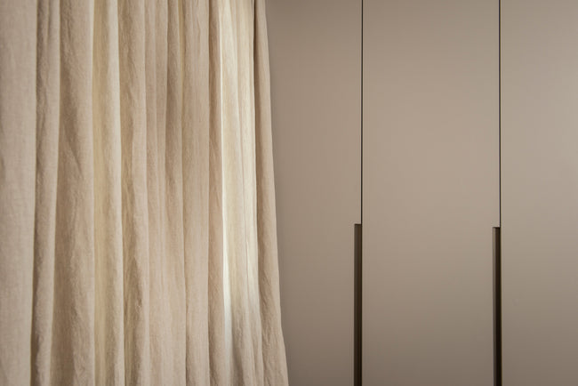 Semitransparent beige linen curtain, naturally falling on wooden floor - discover the allure of breeze oatmeal linen curtain draping gracefully on a wooden surface.