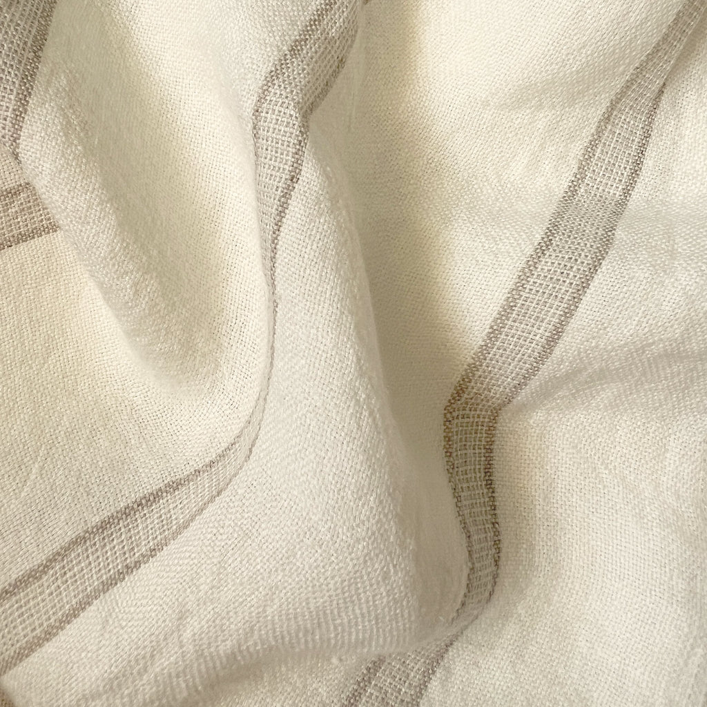 _140 | elodie - ann rees: A light, smooth, and elegant linen fabric accentuated with a delicate beige stripe, perfect for adding a touch of refined beauty to your interior decor.